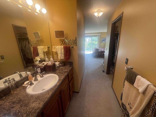12 Country Club Dr Unit 16, Polson, MT 59860 - bathroom featuring a textured ceiling, vanity, a spacious closet, and baseboards