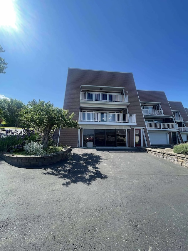 12 Country Club Dr Unit 16, Polson, MT 59860 - view of front of house with asphalt driveway, a garage, and a balcony