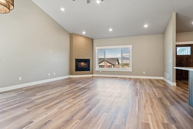 4337 Christian Dr, Missoula, MT 59803 - unfurnished living room with light wood-type flooring, a large fireplace, baseboards, and recessed lighting