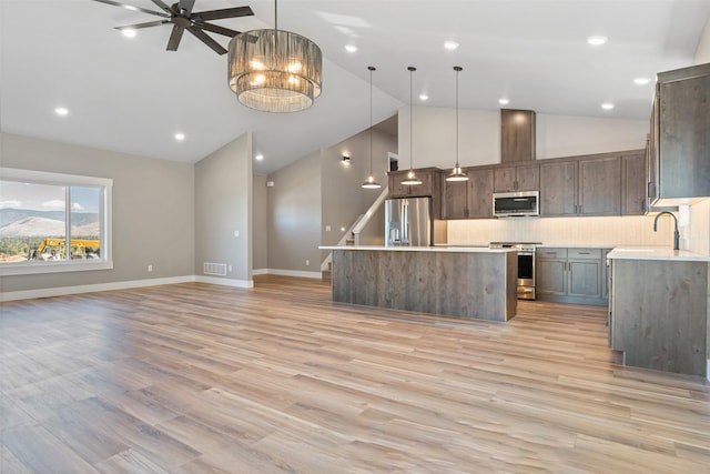 4337 Christian Dr, Missoula, MT 59803 - kitchen featuring stainless steel appliances, open floor plan, a kitchen island, backsplash, and baseboards