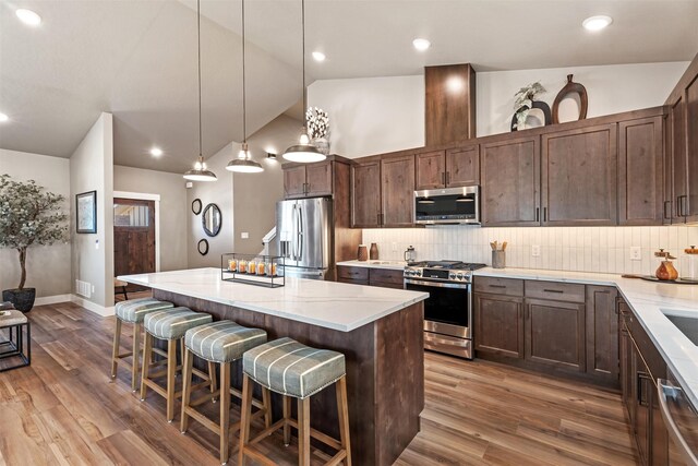 4337 Christian Dr, Missoula, MT 59803 - kitchen featuring stainless steel appliances, lofted ceiling, tasteful backsplash, wood finished floors, and recessed lighting