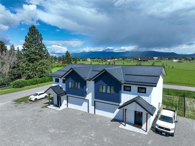 220 Columbia Meadows Dr, Columbia Falls, MT 59912 - modern inspired farmhouse featuring metal roof, driveway, a mountain view, a garage, and board and batten siding