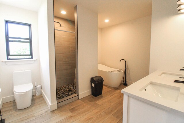 224 Columbia Meadows Dr, Columbia Falls, MT 59912 - full bathroom with a tile shower, toilet, wood finished floors, double vanity, and a freestanding bath