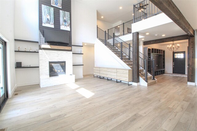 224 Columbia Meadows Dr, Columbia Falls, MT 59912 - unfurnished living room with a towering ceiling, stairway, a chandelier, wood finished floors, and baseboards