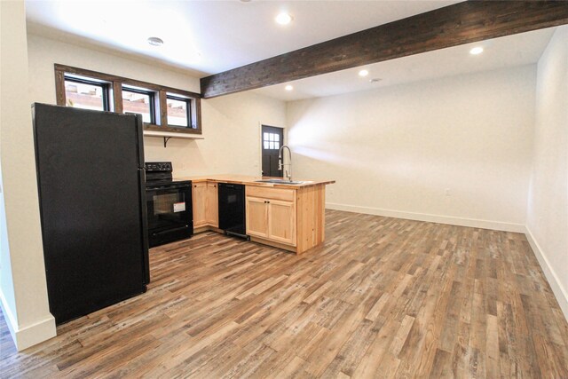 224 Columbia Meadows Dr, Columbia Falls, MT 59912 - kitchen featuring black appliances, a sink, a peninsula, light brown cabinetry, and light wood-style flooring