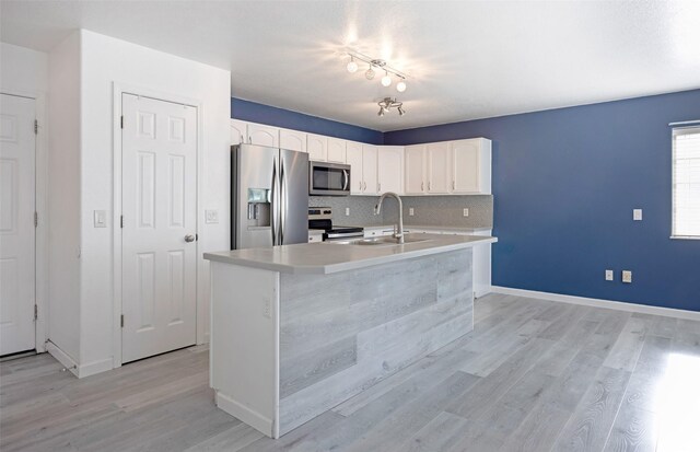 2322 Mary Jane Blvd, Missoula, MT 59808 - kitchen featuring stainless steel appliances, white cabinets, light wood-style floors, light countertops, and backsplash