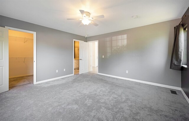 2322 Mary Jane Blvd, Missoula, MT 59808 - unfurnished bedroom with baseboards, a walk in closet, carpet flooring, and ceiling fan