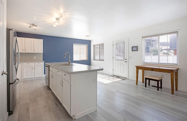 2322 Mary Jane Blvd, Missoula, MT 59808 - kitchen featuring a sink, stainless steel appliances, light wood-style floors, and white cabinets