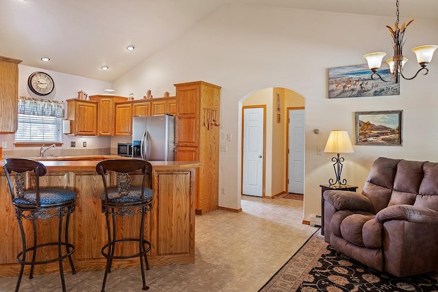 1 Cherry Ct, Clancy, MT 59634 - kitchen featuring stainless steel refrigerator with ice dispenser, a kitchen breakfast bar, open floor plan, arched walkways, and a baseboard radiator