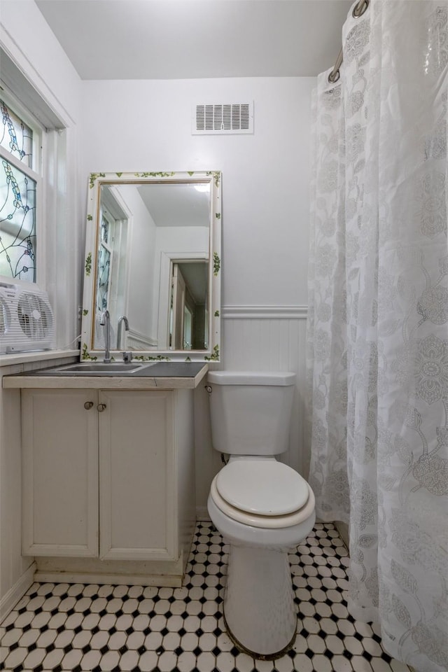 1024 N Warren St, Helena, MT 59601 - bathroom featuring toilet, wainscoting, vanity, and tile patterned floors