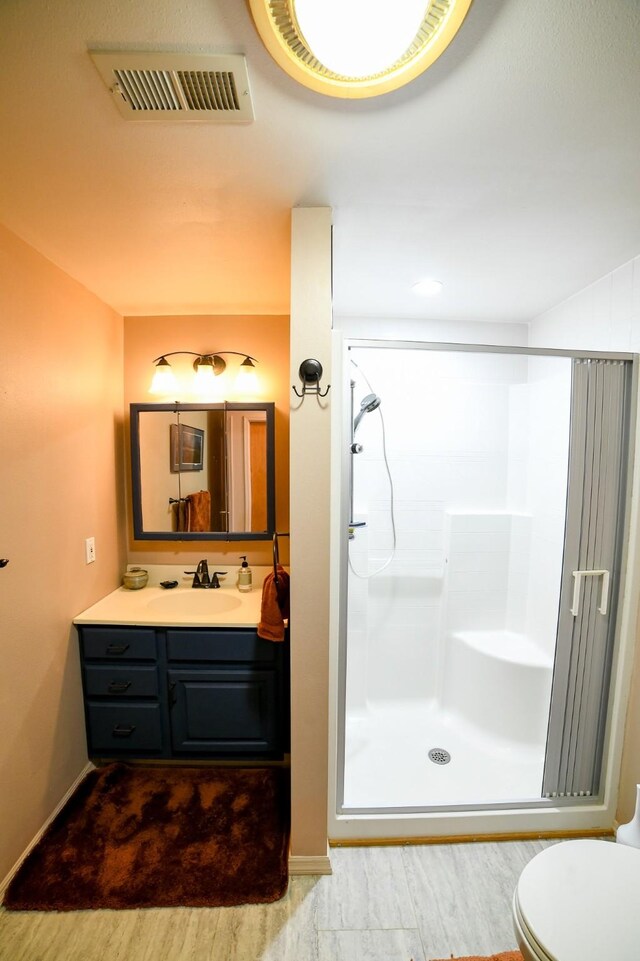 265 Fisher Rd, Great Falls, MT 59405 - bathroom featuring a stall shower, vanity, wood finished floors, and toilet