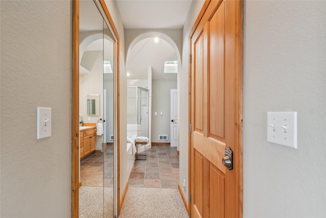 322 Wood Run Dr Unit B, Whitefish, MT 59937 - hallway with light stone finish flooring, baseboards, and arched walkways