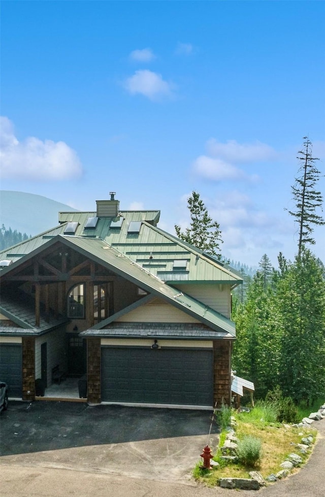 322 Wood Run Dr Unit B, Whitefish, MT 59937 - view of front facade with asphalt driveway, a garage, and a chimney