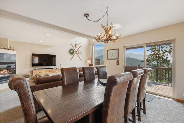 322 Wood Run Dr Unit B, Whitefish, MT 59937 - carpeted dining space with a chandelier, a tile fireplace, and recessed lighting