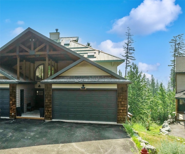 322 Wood Run Dr Unit B, Whitefish, MT 59937 - view of front of home with driveway, a chimney, and an attached garage