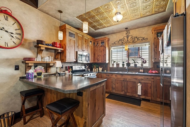 119 5th Ave W, Kalispell, MT 59901 - kitchen featuring appliances with stainless steel finishes, a peninsula, plenty of natural light, and dark countertops