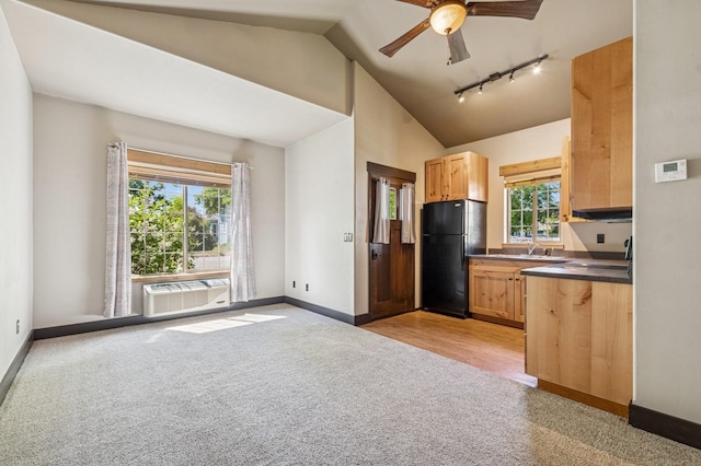 119 5th Ave W, Kalispell, MT 59901 - kitchen with freestanding refrigerator, rail lighting, light colored carpet, lofted ceiling, and healthy amount of natural light