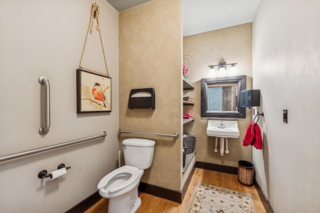 119 5th Ave W, Kalispell, MT 59901 - bathroom featuring toilet, wood finished floors, a sink, and baseboards