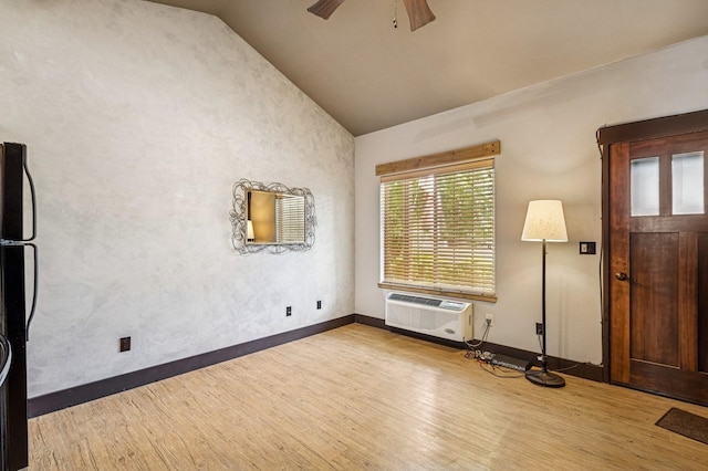 119 5th Ave W, Kalispell, MT 59901 - unfurnished living room featuring wood finished floors, a wall mounted air conditioner, vaulted ceiling, ceiling fan, and baseboards