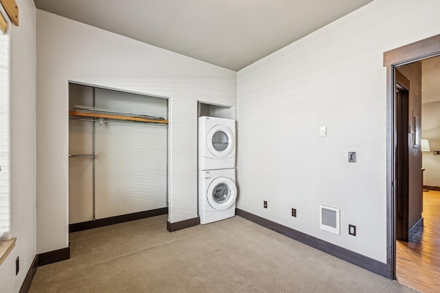 119 5th Ave W, Kalispell, MT 59901 - laundry room with stacked washing machine and dryer, baseboards, and carpet floors
