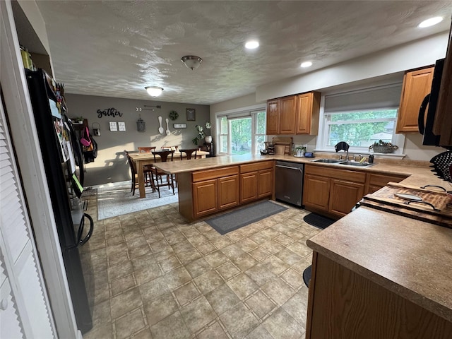1631 Juniper Dr, Havre, MT 59501 - kitchen featuring dishwasher, a sink, a peninsula, brown cabinetry, and recessed lighting