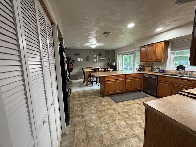 1631 Juniper Dr, Havre, MT 59501 - kitchen with dishwashing machine, a sink, a peninsula, brown cabinetry, and recessed lighting