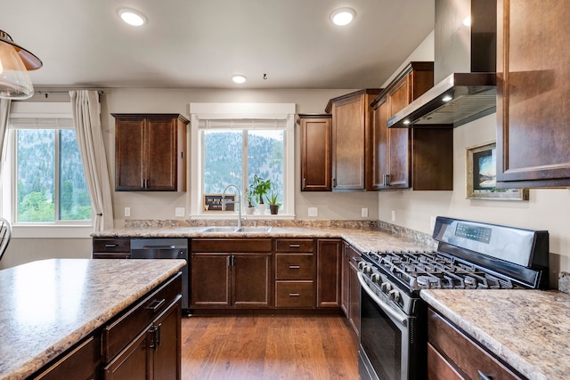 12800 Mill Creek Rd, Lolo, MT 59847 - kitchen featuring stainless steel gas range, wall chimney range hood, a sink, healthy amount of natural light, and recessed lighting