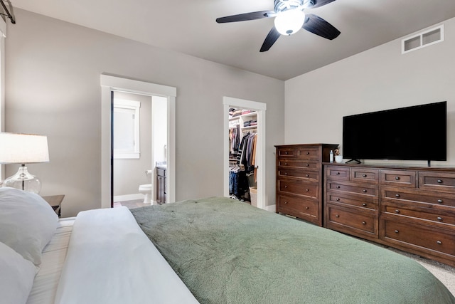 12800 Mill Creek Rd, Lolo, MT 59847 - carpeted bedroom with a spacious closet, a closet, ensuite bath, a ceiling fan, and baseboards