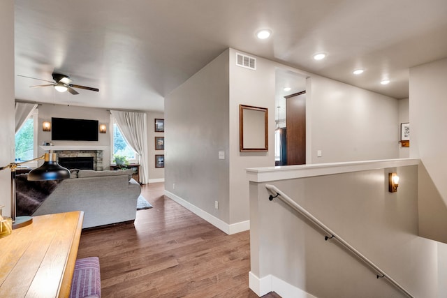 12800 Mill Creek Rd, Lolo, MT 59847 - living room featuring baseboards, wood finished floors, a ceiling fan, a stone fireplace, and recessed lighting