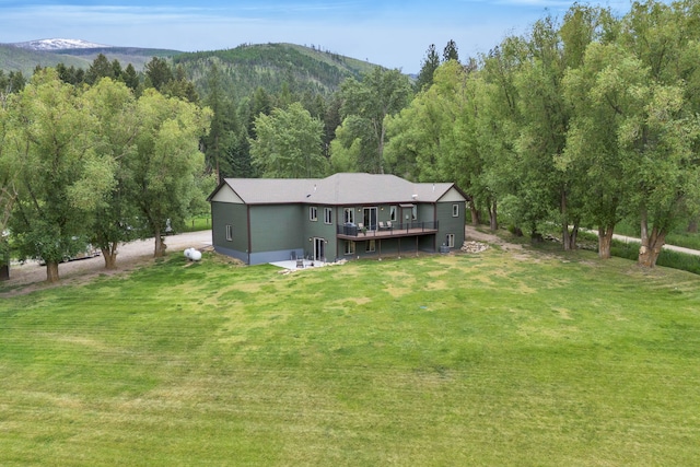 12800 Mill Creek Rd, Lolo, MT 59847 - rear view of property with a yard, a deck with mountain view, and a view of trees