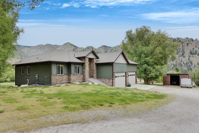 12800 Mill Creek Rd, Lolo, MT 59847 - view of front facade featuring a mountain view, stone siding, driveway, a front lawn, and an attached garage