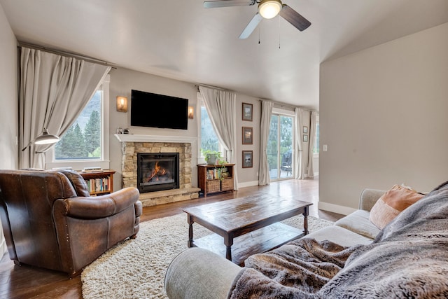 12800 Mill Creek Rd, Lolo, MT 59847 - living area with wood finished floors, a stone fireplace, and plenty of natural light