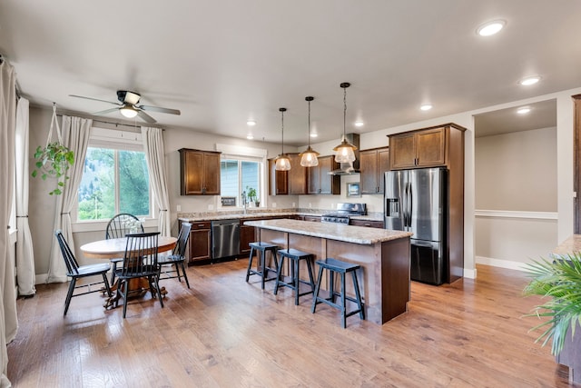 12800 Mill Creek Rd, Lolo, MT 59847 - kitchen with appliances with stainless steel finishes, a center island, a breakfast bar, a ceiling fan, and recessed lighting
