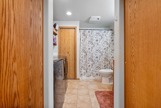 4357 Trumble Creek Rd, Columbia Falls, MT 59912 - full bath featuring washing machine and clothes dryer, toilet, tile patterned floors, and a shower with curtain