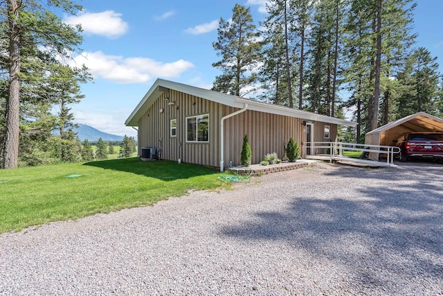 4357 Trumble Creek Rd, Columbia Falls, MT 59912 - view of property exterior with central AC, board and batten siding, a detached carport, a yard, and a mountain view