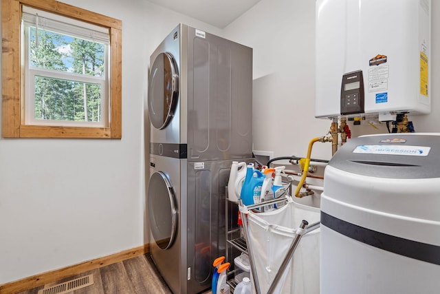 4357 Trumble Creek Rd, Columbia Falls, MT 59912 - laundry area featuring stacked washer / dryer, baseboards, wood finished floors, and tankless water heater