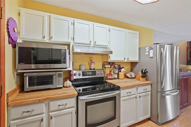 1021 Vallejo Rd, Helena, MT 59602 - kitchen featuring appliances with stainless steel finishes, under cabinet range hood, butcher block counters, and white cabinetry