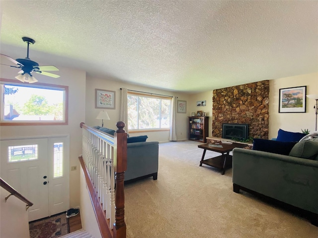 1655 Sunflower Dr, Missoula, MT 59802 - living area featuring a textured ceiling, a ceiling fan, light colored carpet, and a stone fireplace