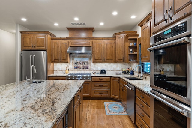 74 Wood Ridge Dr, Columbia Falls, MT 59912 - kitchen featuring appliances with stainless steel finishes, a sink, under cabinet range hood, light wood-style floors, and recessed lighting