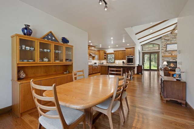 74 Wood Ridge Dr, Columbia Falls, MT 59912 - dining space with vaulted ceiling, light wood finished floors, a fireplace, baseboards, and recessed lighting