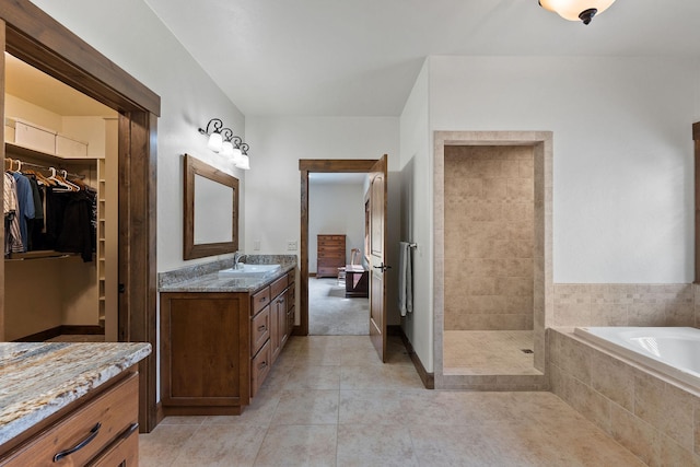 74 Wood Ridge Dr, Columbia Falls, MT 59912 - full bathroom featuring vanity, a bath, tile patterned floors, a walk in closet, and tiled shower