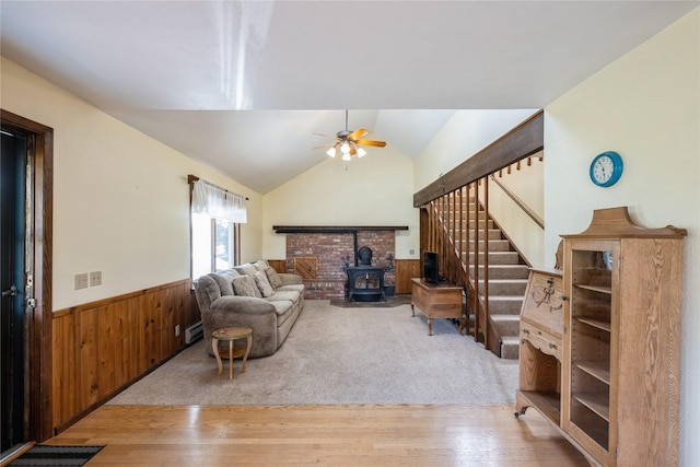 965 Ranch Ln, Kalispell, MT 59901 - living area featuring a wood stove, ceiling fan, wainscoting, wood walls, and wood finished floors