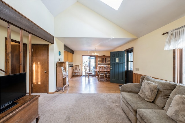 965 Ranch Ln, Kalispell, MT 59901 - living room with a chandelier, light colored carpet, a wainscoted wall, high vaulted ceiling, and a skylight