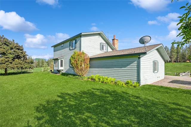965 Ranch Ln, Kalispell, MT 59901 - view of home's exterior with a chimney, a lawn, and roof with shingles