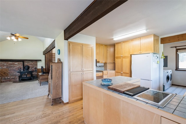 965 Ranch Ln, Kalispell, MT 59901 - kitchen featuring freestanding refrigerator, light brown cabinetry, tile counters, a wood stove, and ceiling fan