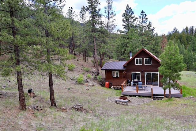 208 Paul Creek Ln, Cascade, MT 59421 - rear view of house with a deck, a view of trees, an outdoor fire pit, metal roof, and log veneer siding