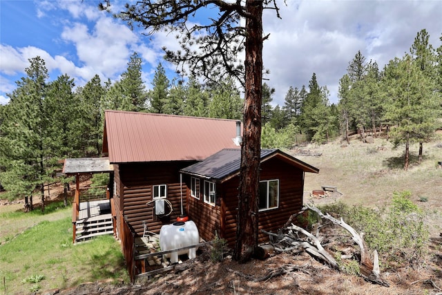 208 Paul Creek Ln, Cascade, MT 59421 - view of side of property with faux log siding, a wooden deck, and metal roof
