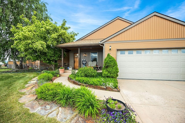 1399 Mackinaw Loop, Somers, MT 59932 - view of front of house featuring a garage, a front lawn, concrete driveway, and covered porch