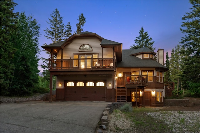 244 Pine Valley Ct, Columbia Falls, MT 59912 - view of front of home with a chimney, driveway, an attached garage, stairs, and a balcony