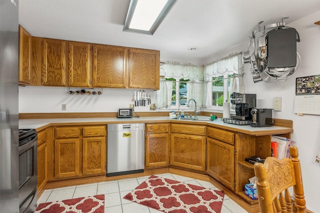 238 Red Fox Rd, Lolo, MT 59847 - kitchen featuring stainless steel dishwasher, a sink, range, light countertops, and brown cabinetry